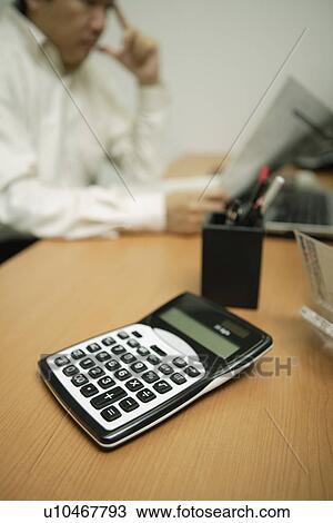 Stock Image - Calculator on a desk, close-up. Fotosearch