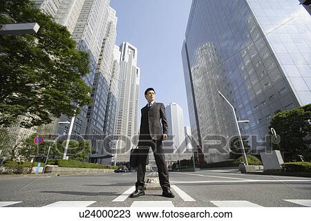Businessman amid office buildings View Large Photo Image Stock Image - Businessman amid office buildings. Fotosearch