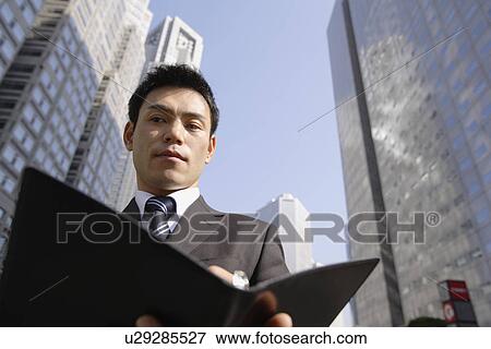 Businessman browsing a file, portrait View Large Photo Image Stock Photo - Businessman browsing a file, portrait. Fotosearch