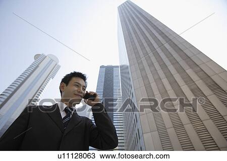 Businessman conversing on a cellphone View Large Photo Image Stock Image - Businessman conversing on a cellphone. Fotosearch