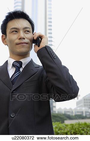Stock Image - Businessman conversing on a cellphone, portrait. Fotosearch