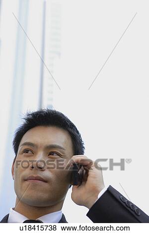 Stock Photo - Businessman conversing on a cellphone, close-up. Fotosearch