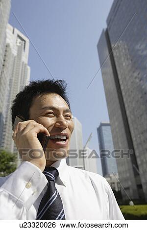 Businessman conversing on a cellphone, portrait View Large Photo Image Stock Photograph - Businessman conversing on a cellphone, portrait. Fotosearch