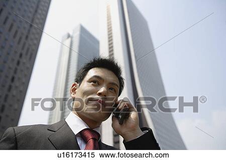 Businessman conversing on a cellphone, portrait View Large Photo Image Stock Photography - Businessman conversing on a cellphone, portrait. Fotosearch
