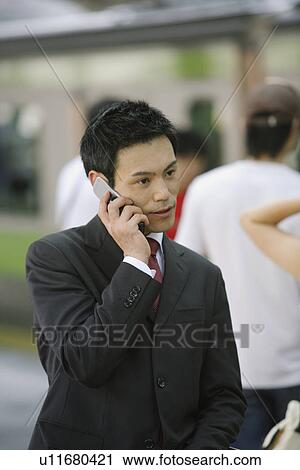 Stock Image - Businessman conversing on his cellphone, portrait. Fotosearch