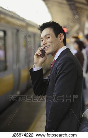 Stock Image - Businessman conversing on his cellphone, portrait. Fotosearch