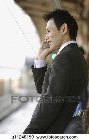Stock Photo - Businessman conversing on his cellphone, portrait. Fotosearch