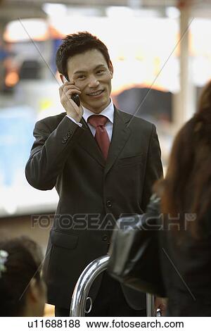 Stock Photo - Businessman conversing on his cellphone, portrait. Fotosearch
