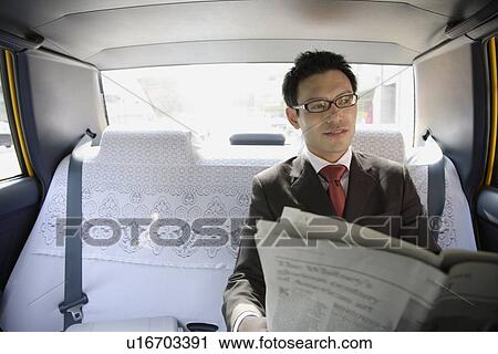 Businessman reading newspaper in car, portrait View Large Photo Image Stock Image - Businessman reading newspaper in car, portrait. Fotosearch