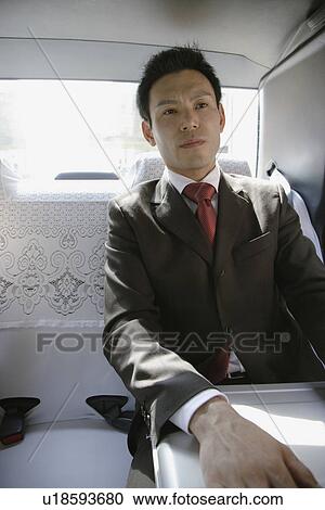 Stock Image - Businessman sitting in car, portrait. Fotosearch