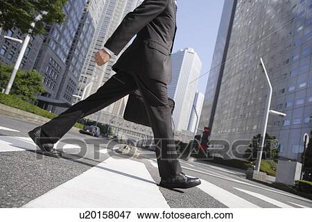 Stock Photo - Businessman walking on a crosswalk. Fotosearch