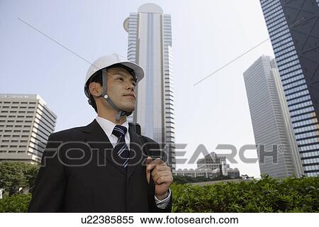 Businessman wearing a hard hat View Large Photo Image Stock Photography - Businessman wearing a hard hat. Fotosearch