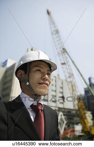 Stock Image - Businessman with a hard hat, portrait. Fotosearch