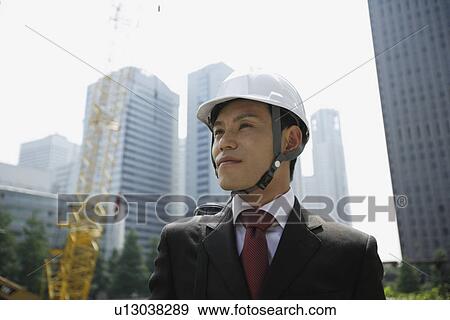 Stock Photo - Businessman with a hard hat, portrait. Fotosearch