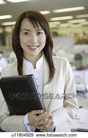 Businesswoman holding a folder, portrait View Large Photo Image Stock Photo - Businesswoman holding a folder, portrait. Fotosearch