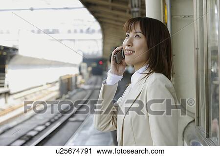 Stock Image - Businesswoman conversing on a cellphone, portrait. Fotosearch