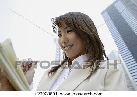 Businesswoman holding a book and a pen, portrait View Large Photo Image Stock Image - Businesswoman holding a book and a pen, portrait. Fotosearch