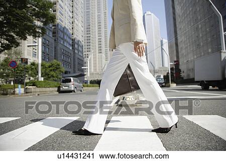 Cropped view of a woman walking on a crosswalk View Large Photo Image Stock Image - Cropped view of a woman walking on a crosswalk. Fotosearch