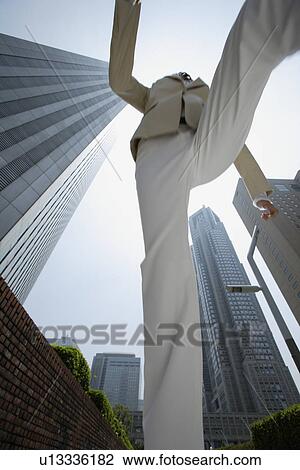 Stock Image - Low angle view of a businesswoman jumping. Fotosearch