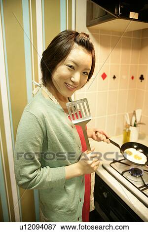 A young woman at kitchen, cooking the fried eggs View Large Photo Image Stock Photo - A young woman at kitchen, cooking the fried eggs. Fotosearch