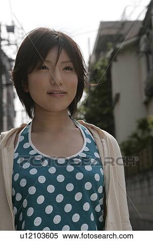 Stock Photography - A young woman standing in the lane on a bright sunny day. Fotosearch