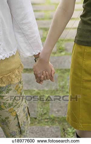 Front view of two women holding each others hand View Large Photo Image Stock Image - Front view of two women holding each others hand. Fotosearch