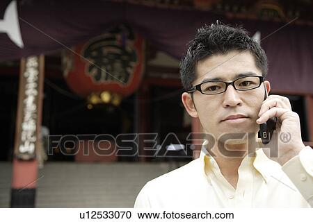 Stock Image - A young man using cellphone. Fotosearch