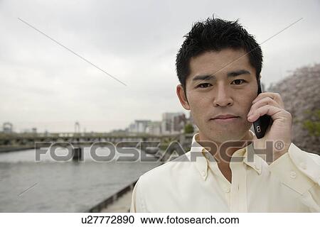 Stock Image - A young man using cellphone. Fotosearch