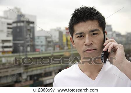 A young man using cellphone View Large Photo Image Stock Photo - A young man using cellphone. Fotosearch