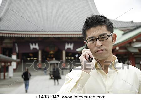 A young man using cellphone View Large Photo Image Stock Photo - A young man using cellphone. Fotosearch