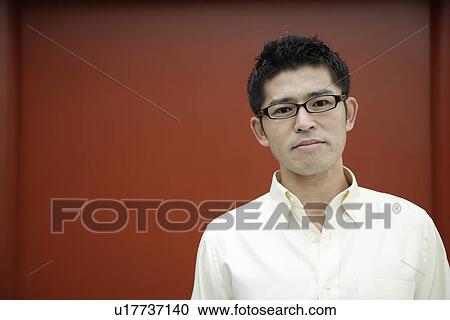 Stock Image - Close-up of a young man wearing glasses. Fotosearch