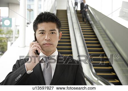 Portrait of a young businessman using mobile phone View Large Photo Image Stock Photo - Portrait of a young businessman using mobile phone. Fotosearch