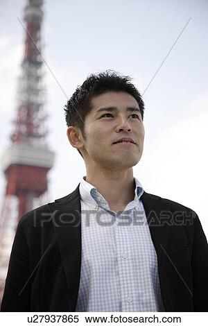 Stock Photography - View of a smiling young man looking away. Fotosearch