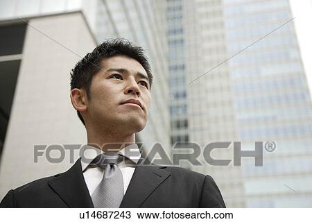 View of a young businessman looking away View Large Photo Image Stock Image - View of a young businessman looking away. Fotosearch