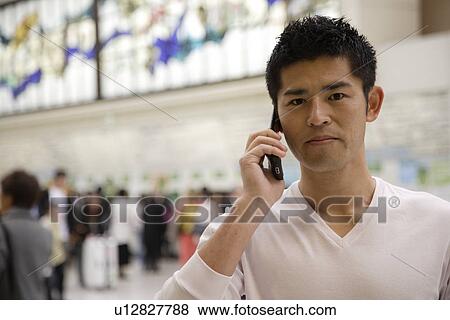 Stock Photo - Young man using cellphone. Fotosearch