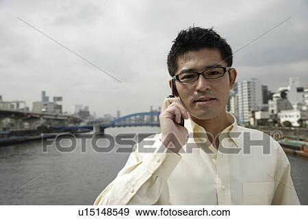 Stock Photo - Young man using cellphone. Fotosearch