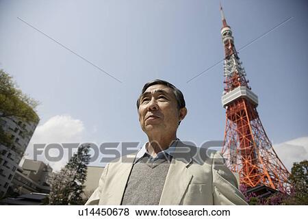 A senior man standing with a tower in background View Large Photo Image Stock Photo - A senior man standing with a tower in background. Fotosearch