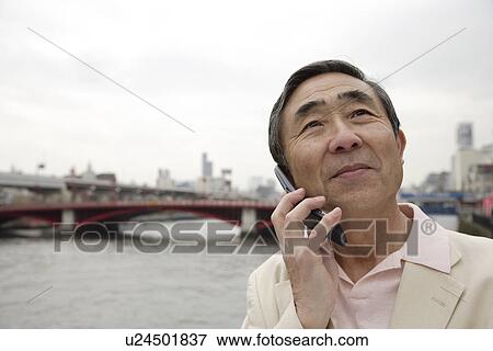 Stock Photo - Close-up of a senior man using mobile phone. Fotosearch