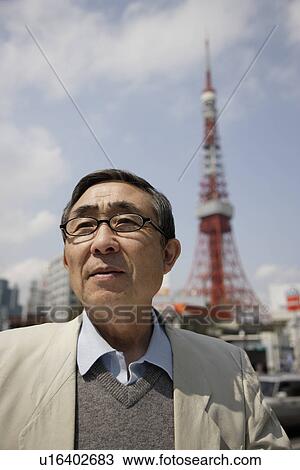 Close-up of senior man with tower in background View Large Photo Image Stock Image - Close-up of senior man with tower in background. Fotosearch