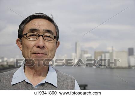 Stock Image - Portrait of a smiling senior man wearing glasses. Fotosearch