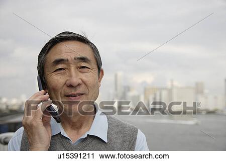 Portrait of a smiling senior man using mobile phone View Large Photo Image Stock Image - Portrait of a smiling senior man using mobile phone. Fotosearch