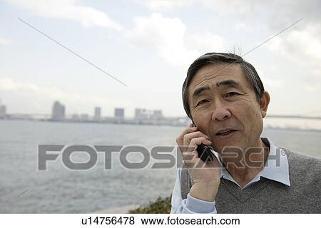 Portrait of a smiling senior man using mobile phone View Large Photo Image Stock Photo - Portrait of a smiling senior man using mobile phone. Fotosearch