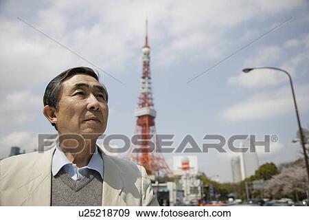Stock Photo - Senior man standing with tower in background. Fotosearch