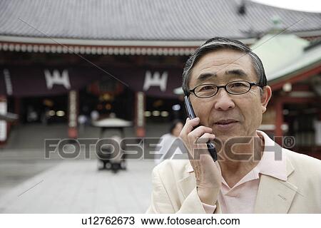 Stock Image - View a senior man using mobile phone. Fotosearch