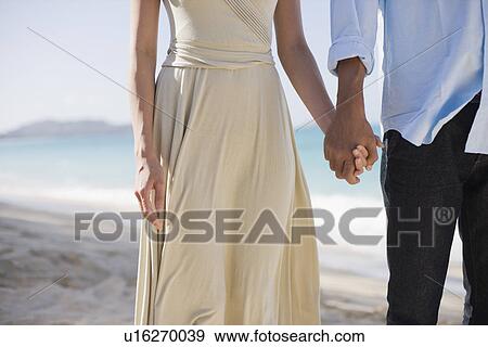 Stock Photo - A couple holding hands. Fotosearch