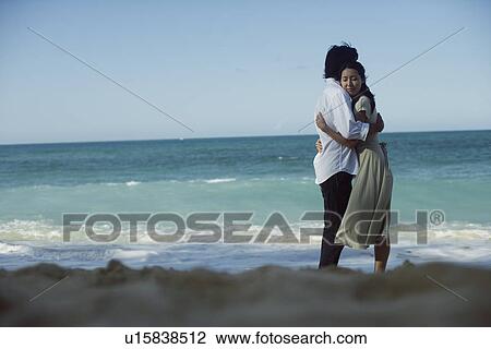 Stock Image - A young couple hugging each other at beach. Fotosearch