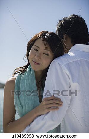 Stock Image - A young couple hugging each other. Fotosearch