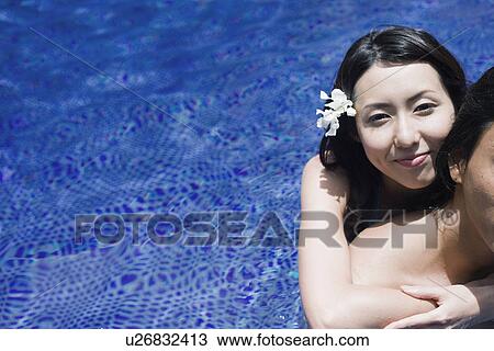 Stock Image - A young couple in pool. Fotosearch