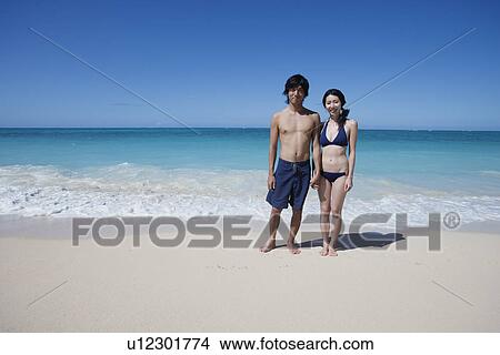 A young couple standing at beach View Large Photo Image Picture - A young couple standing at beach. Fotosearch