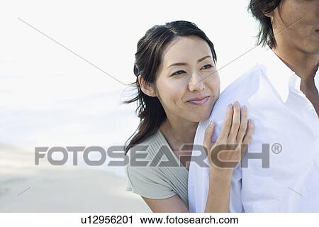 Stock Image - A young couple standing together. Fotosearch